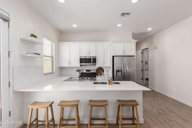 4077 S Quinn Ave, Gilbert, AZ 85297 - kitchen with a sink, stainless steel appliances, a peninsula, tasteful backsplash, and visible vents