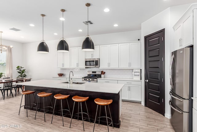 4077 S Quinn Ave, Gilbert, AZ 85297 - kitchen featuring stainless steel appliances, tasteful backsplash, a sink, and light wood-type flooring