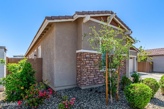 4077 S Quinn Ave, Gilbert, AZ 85297 - view of front facade with an attached garage, fence, stone siding, and stucco siding