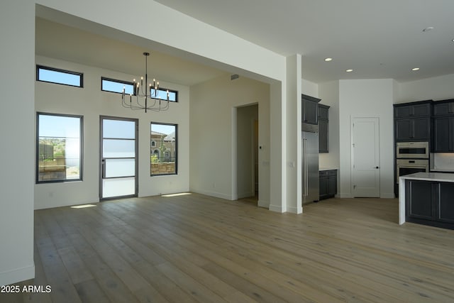 13290 E Ln Junta Rd, Scottsdale, AZ 85255 - unfurnished living room with a chandelier, light wood-type flooring, recessed lighting, and baseboards