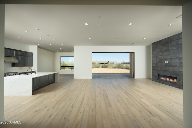 13290 E Ln Junta Rd, Scottsdale, AZ 85255 - unfurnished living room with light wood-type flooring, a tile fireplace, and recessed lighting