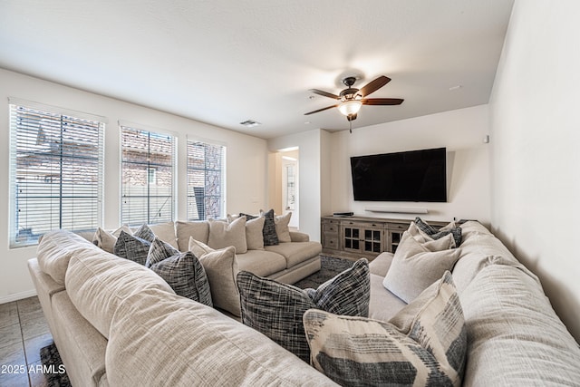 living area with ceiling fan and baseboards