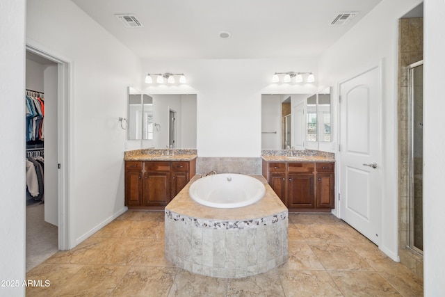 full bath with a shower stall, a bath, and two vanities