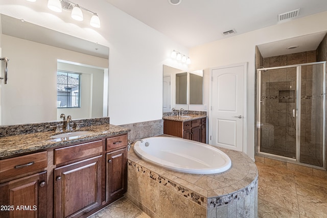 full bathroom featuring a stall shower, a bath, and two vanities