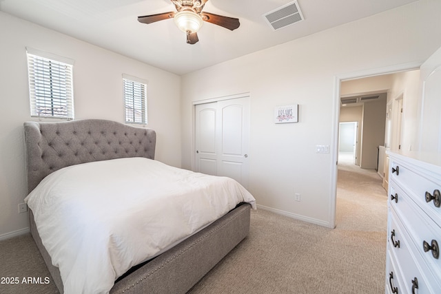 bedroom with light carpet, a closet, and baseboards