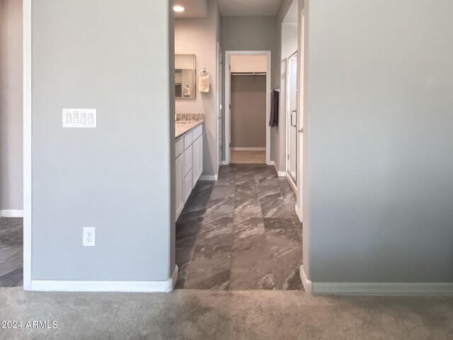 hall featuring dark colored carpet