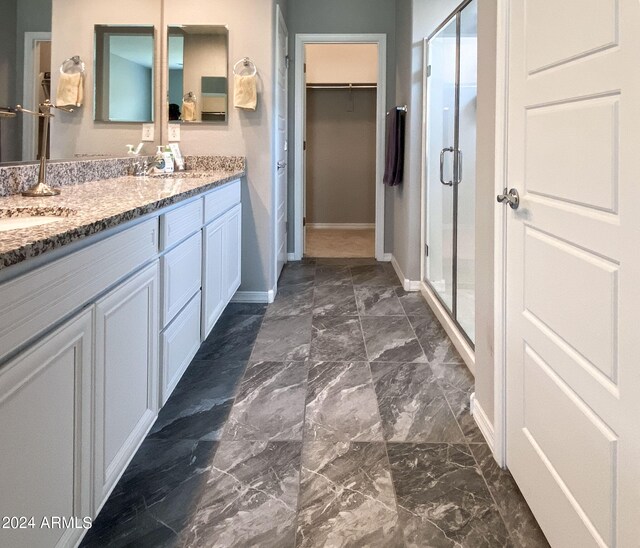 bathroom featuring vanity and a shower with door