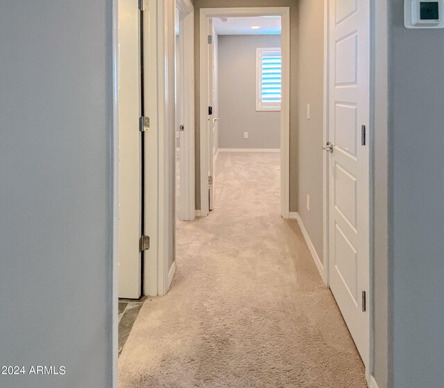 corridor featuring light colored carpet