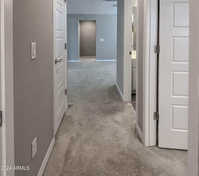 corridor featuring light colored carpet