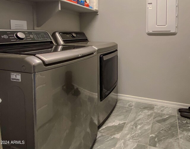 washroom featuring electric panel and washer and clothes dryer