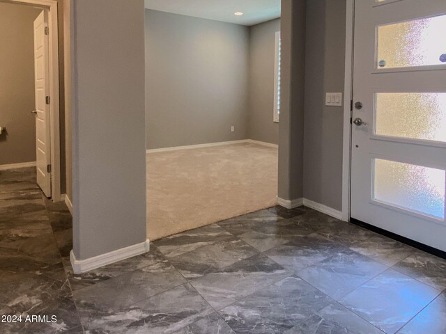 view of carpeted foyer entrance