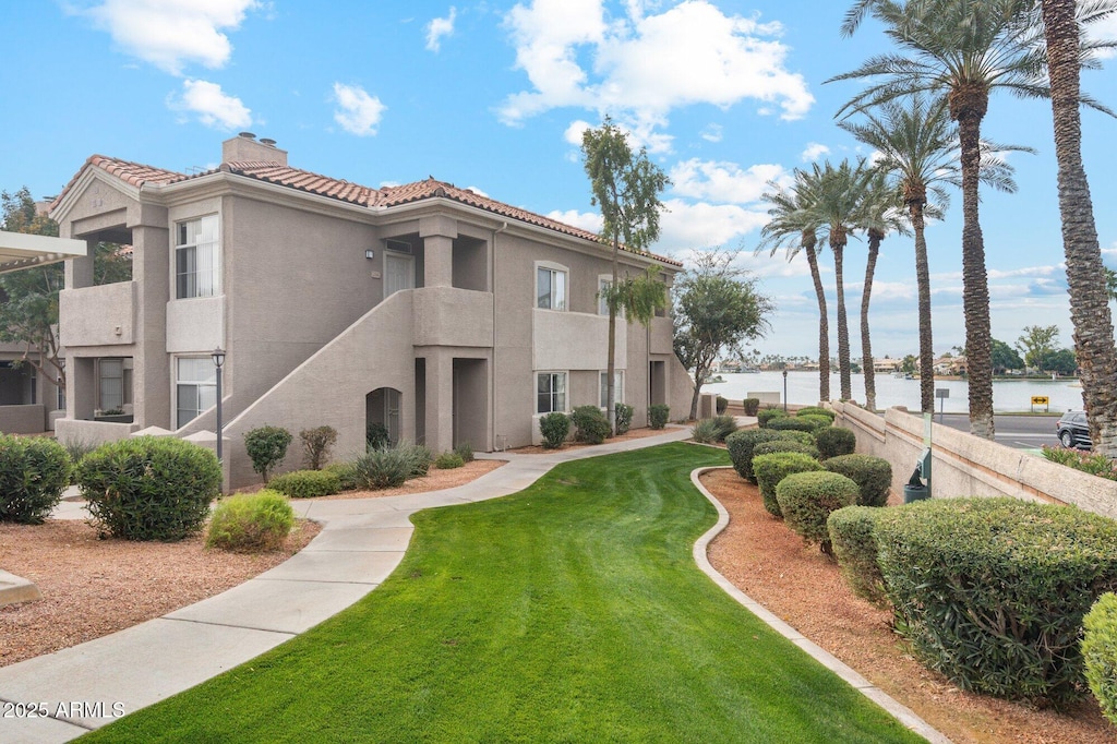 view of property's community featuring a water view and a yard