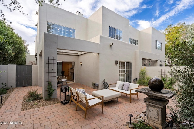 rear view of house with an outdoor living space and a patio area