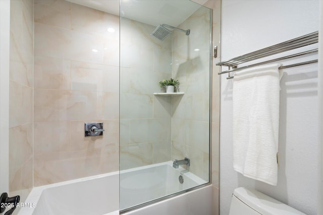 bathroom featuring tiled shower / bath combo and toilet