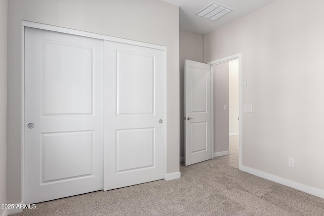 unfurnished bedroom with baseboards, a closet, visible vents, and carpet flooring