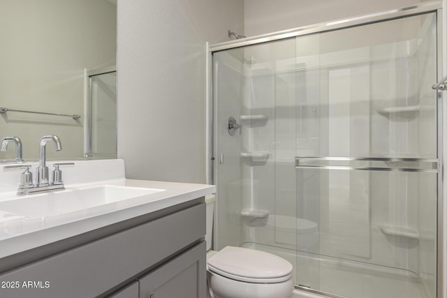 bathroom with toilet, a stall shower, and vanity