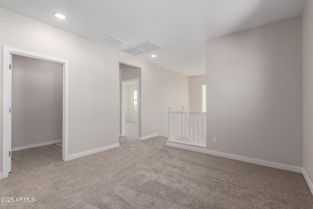 carpeted empty room with recessed lighting, visible vents, and baseboards