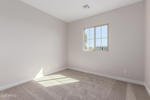 spare room featuring baseboards, visible vents, and carpet flooring