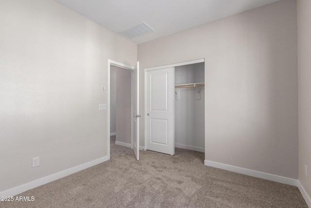 unfurnished bedroom featuring carpet floors, a closet, visible vents, and baseboards