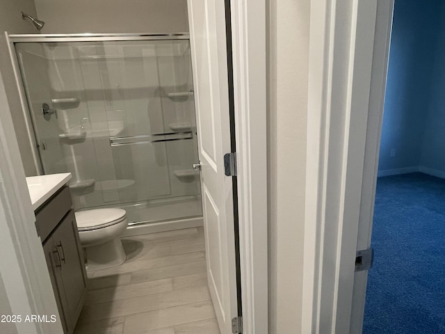 full bath with toilet, a stall shower, and vanity