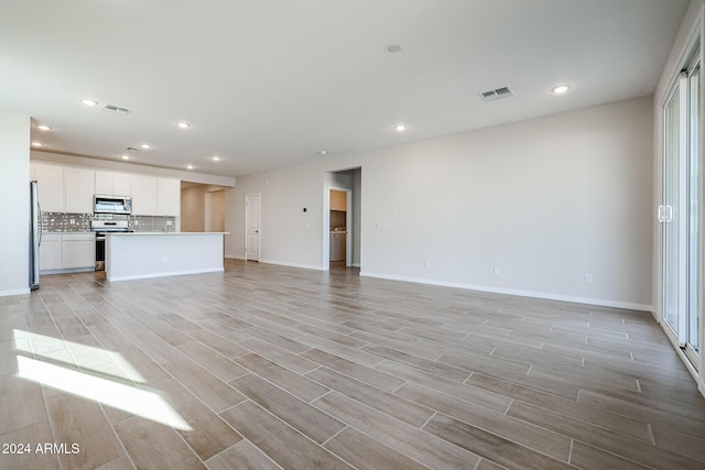 unfurnished living room with light wood-type flooring