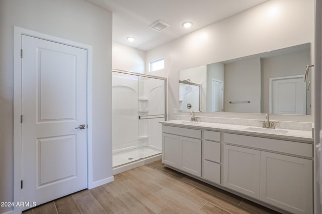 bathroom featuring hardwood / wood-style floors, vanity, and walk in shower