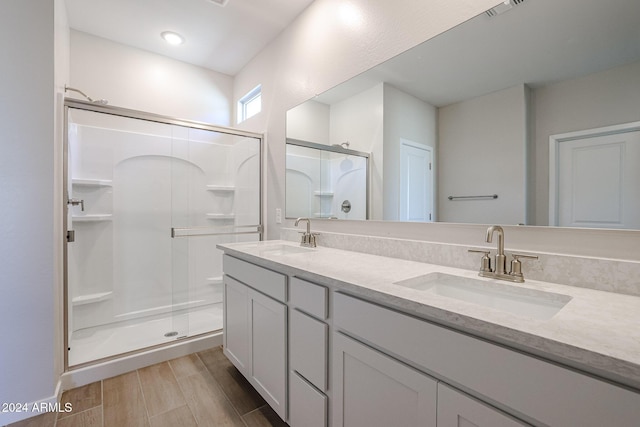 bathroom with hardwood / wood-style floors, vanity, and walk in shower