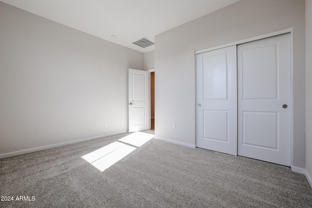 unfurnished bedroom with carpet flooring and a closet