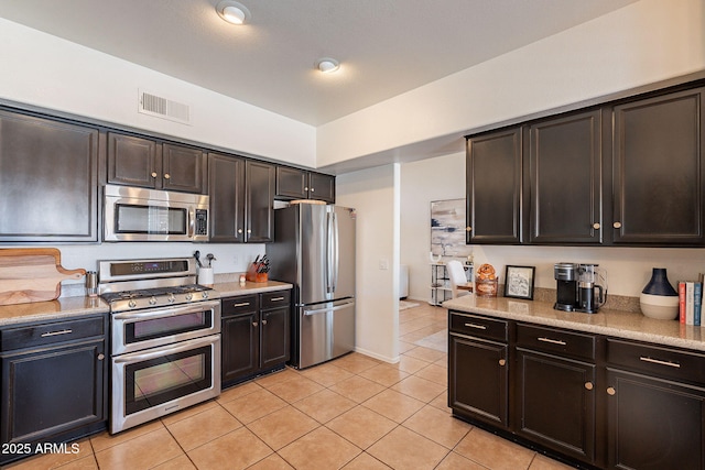 1125 S Larkspur St, Gilbert, AZ 85296 - kitchen featuring stainless steel appliances, light tile patterned flooring, and dark brown cabinets