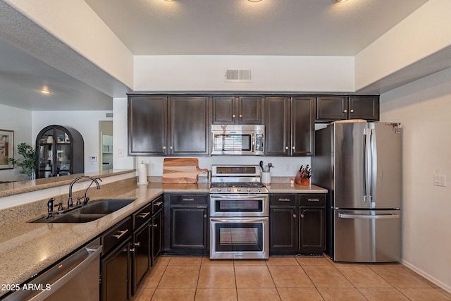 1125 S Larkspur St, Gilbert, AZ 85296 - kitchen with appliances with stainless steel finishes, a sink, light tile patterned floors, and light stone countertops