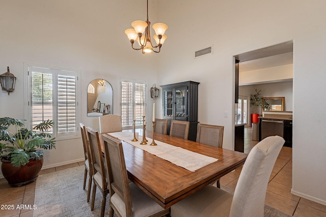 1125 S Larkspur St, Gilbert, AZ 85296 - dining space featuring light tile patterned floors, a chandelier, a towering ceiling, and baseboards