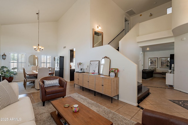1125 S Larkspur St, Gilbert, AZ 85296 - tiled living room featuring high vaulted ceiling, a chandelier, baseboards, and stairs