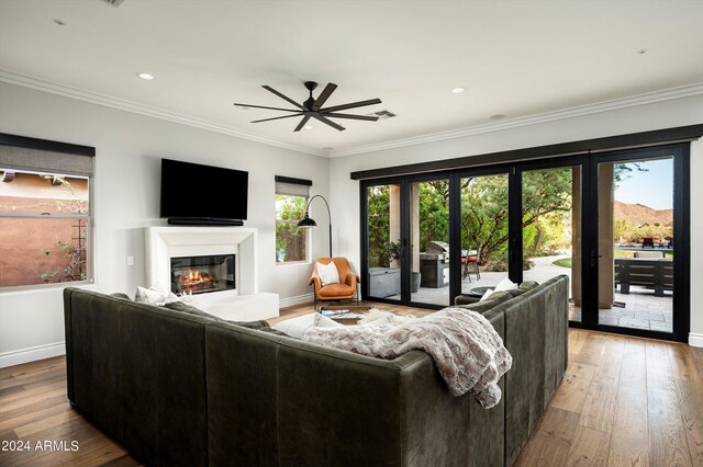 living room with ceiling fan, sink, hardwood / wood-style floors, and crown molding