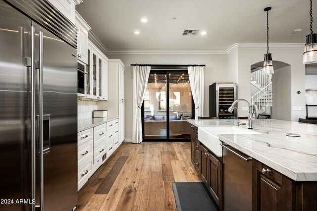 kitchen with light stone countertops, exhaust hood, white cabinetry, double oven range, and a mountain view