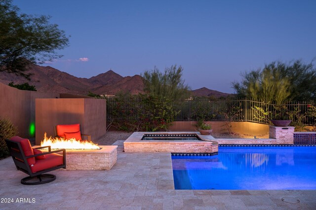 view of patio / terrace with a mountain view and an outdoor living space with a fire pit