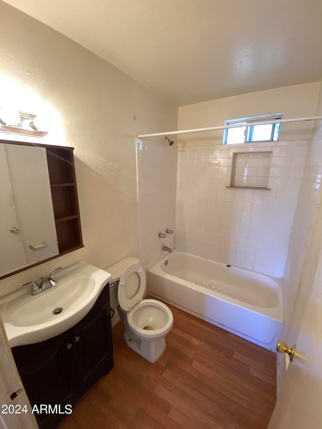 full bathroom with tiled shower / bath, vanity, toilet, and hardwood / wood-style flooring