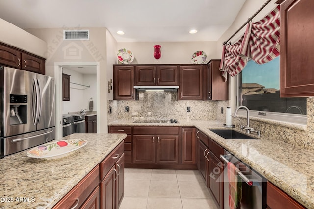 kitchen with visible vents, backsplash, appliances with stainless steel finishes, light tile patterned flooring, and a sink