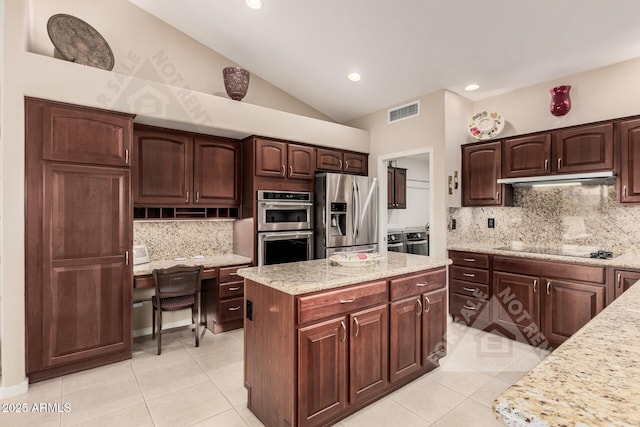 kitchen featuring light tile patterned flooring, vaulted ceiling, dark brown cabinets, appliances with stainless steel finishes, and light stone countertops