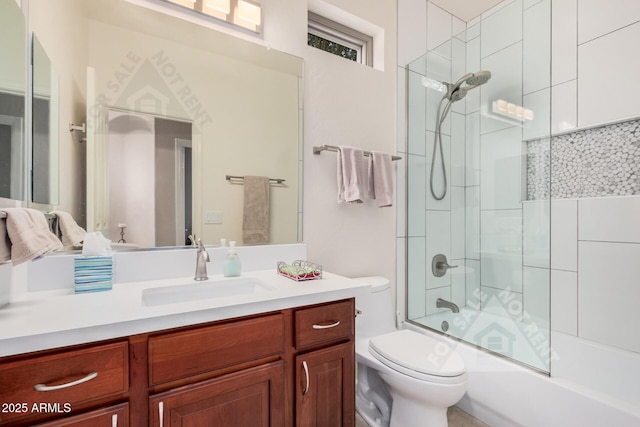 bathroom featuring combined bath / shower with glass door, vanity, and toilet