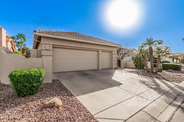 view of front of home with a tile roof, driveway, an attached garage, and stucco siding