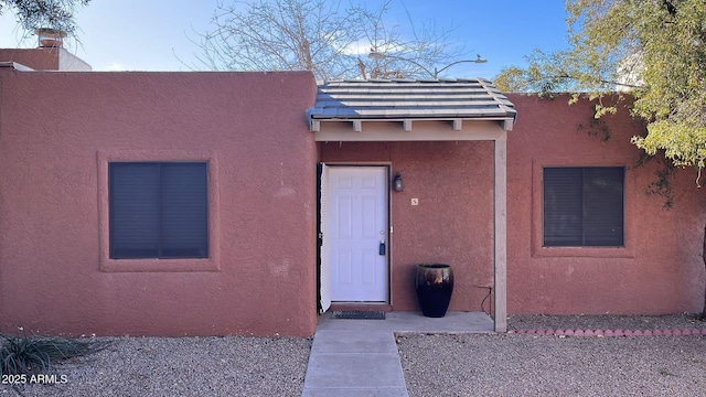 doorway to property featuring stucco siding