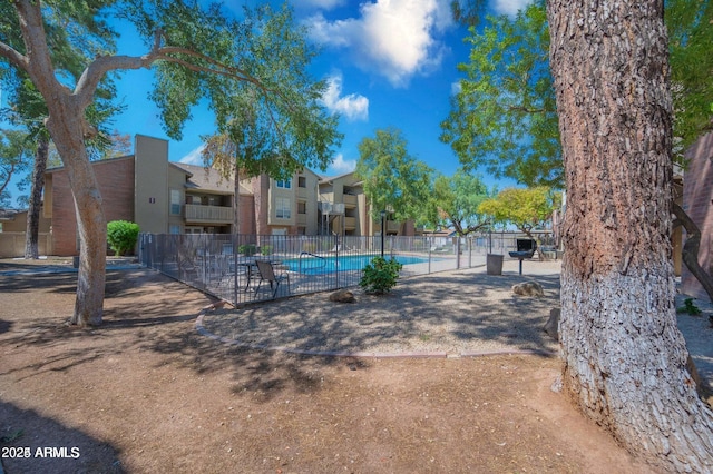 exterior space featuring a swimming pool and fence