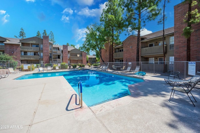 pool featuring a residential view, a patio, and fence