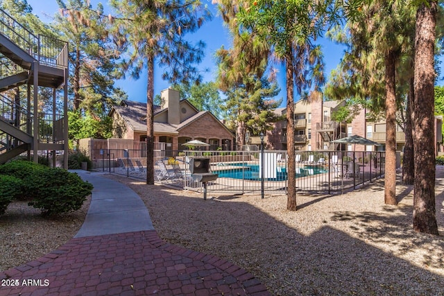 exterior space featuring a swimming pool and fence