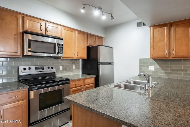 kitchen with decorative backsplash, sink, and stainless steel appliances