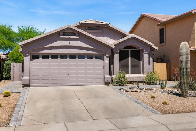 4704 E Melinda Ln, Phoenix, AZ 85050 - view of front of home featuring stucco siding, driveway, an attached garage, a tiled roof, and a gate