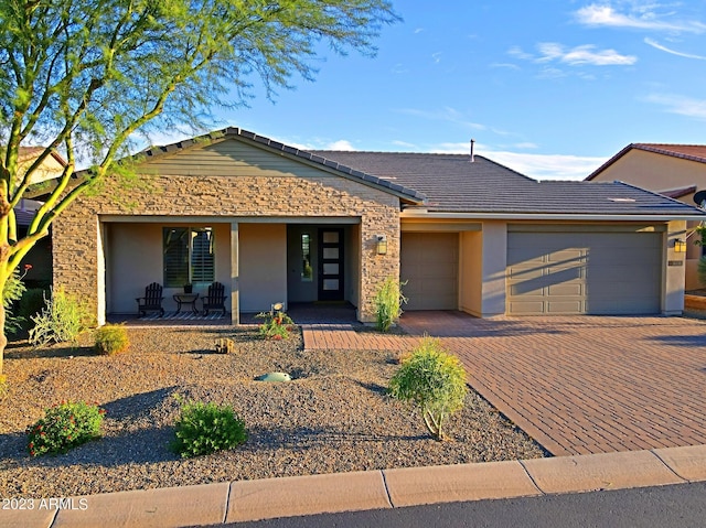 single story home featuring a tiled roof, an attached garage, decorative driveway, a porch, and stucco siding