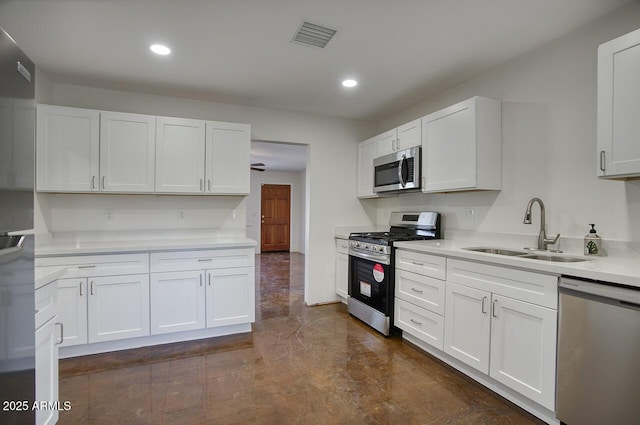 3841 N 21st Ave, Phoenix, AZ 85015 - kitchen featuring stainless steel appliances, a sink, white cabinetry, and recessed lighting