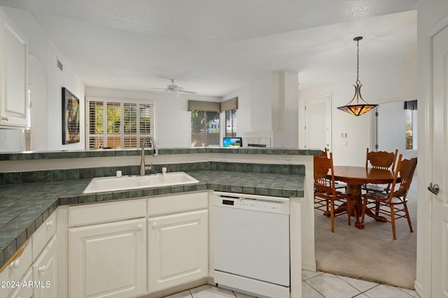 kitchen with white dishwasher, sink, ceiling fan, light colored carpet, and white cabinetry