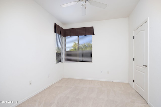 carpeted spare room featuring ceiling fan